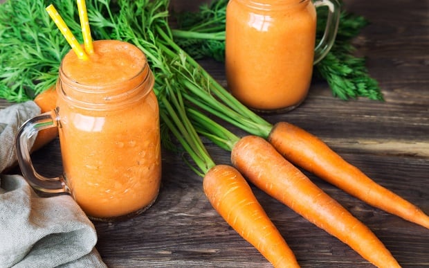 carrot juice and fresh carrots with tops
