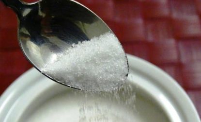 spoon pouring sugar into a pot