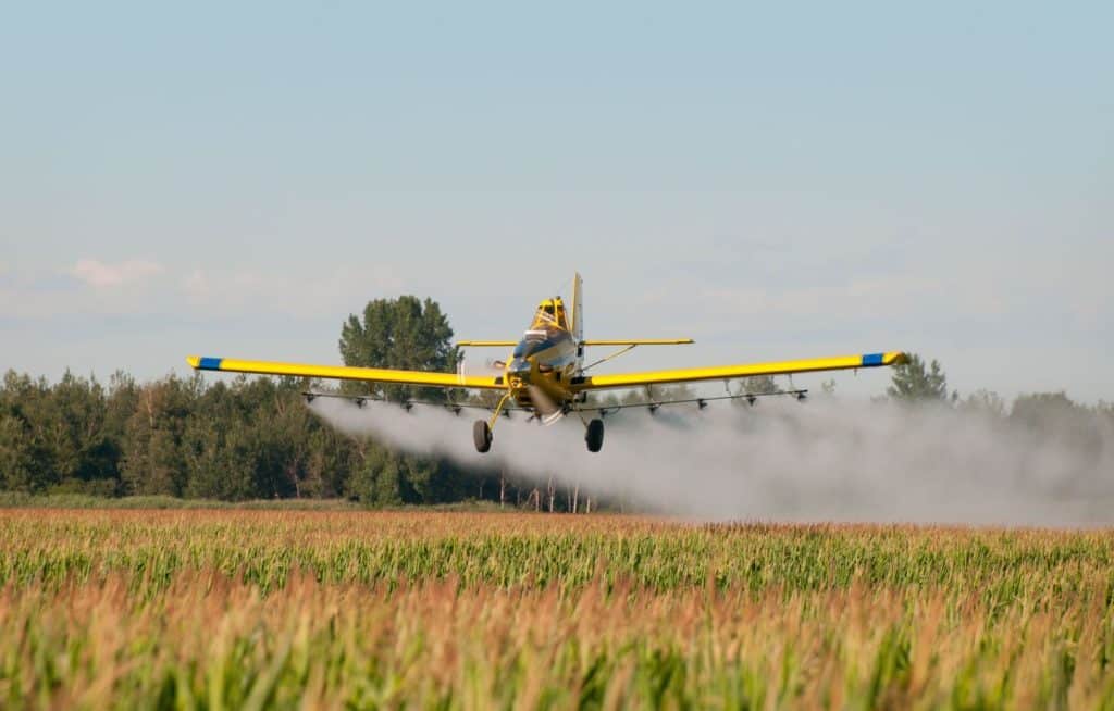 Airplane applying pesticide in the field