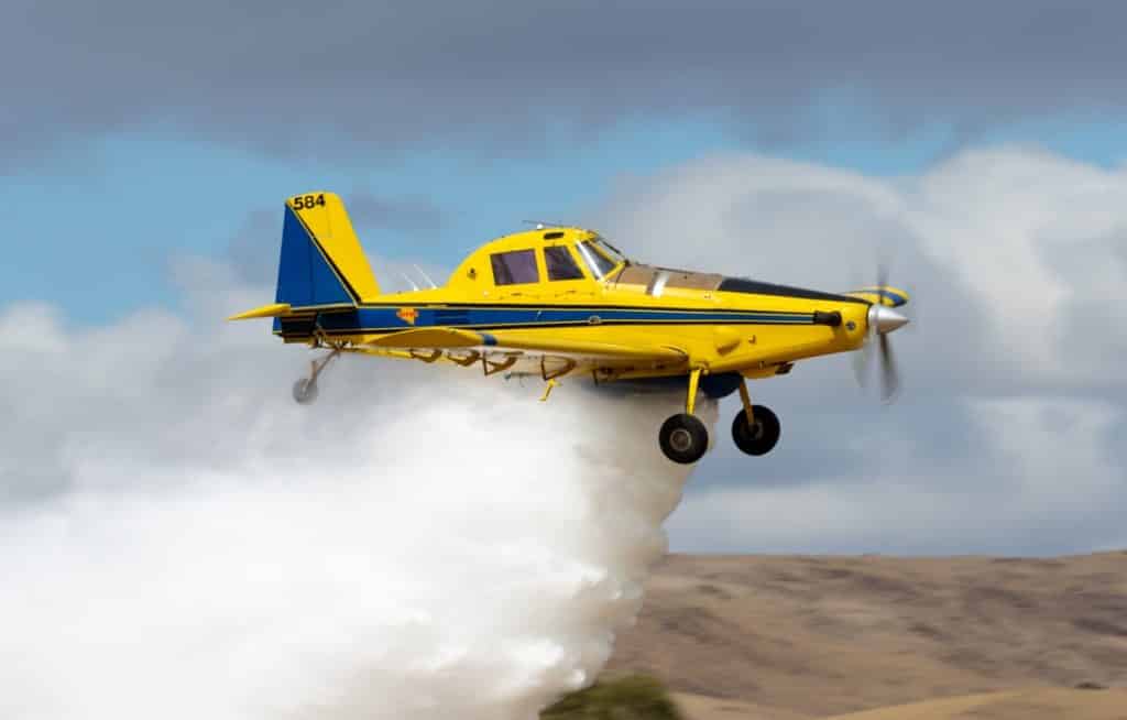 Yellow agricultural plane spraying
