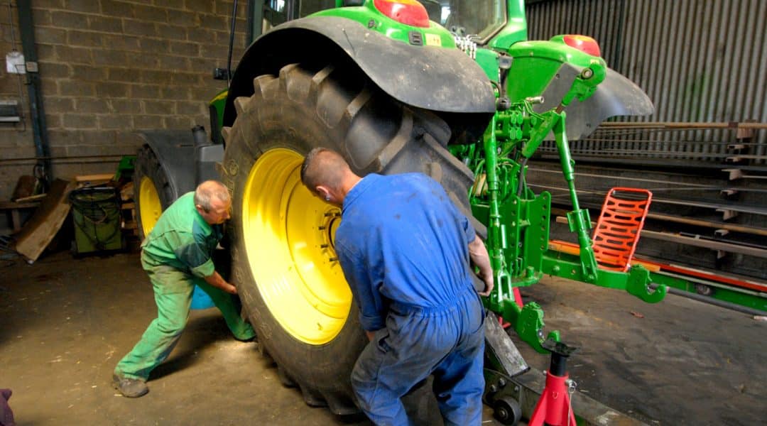Men changing tractor tire