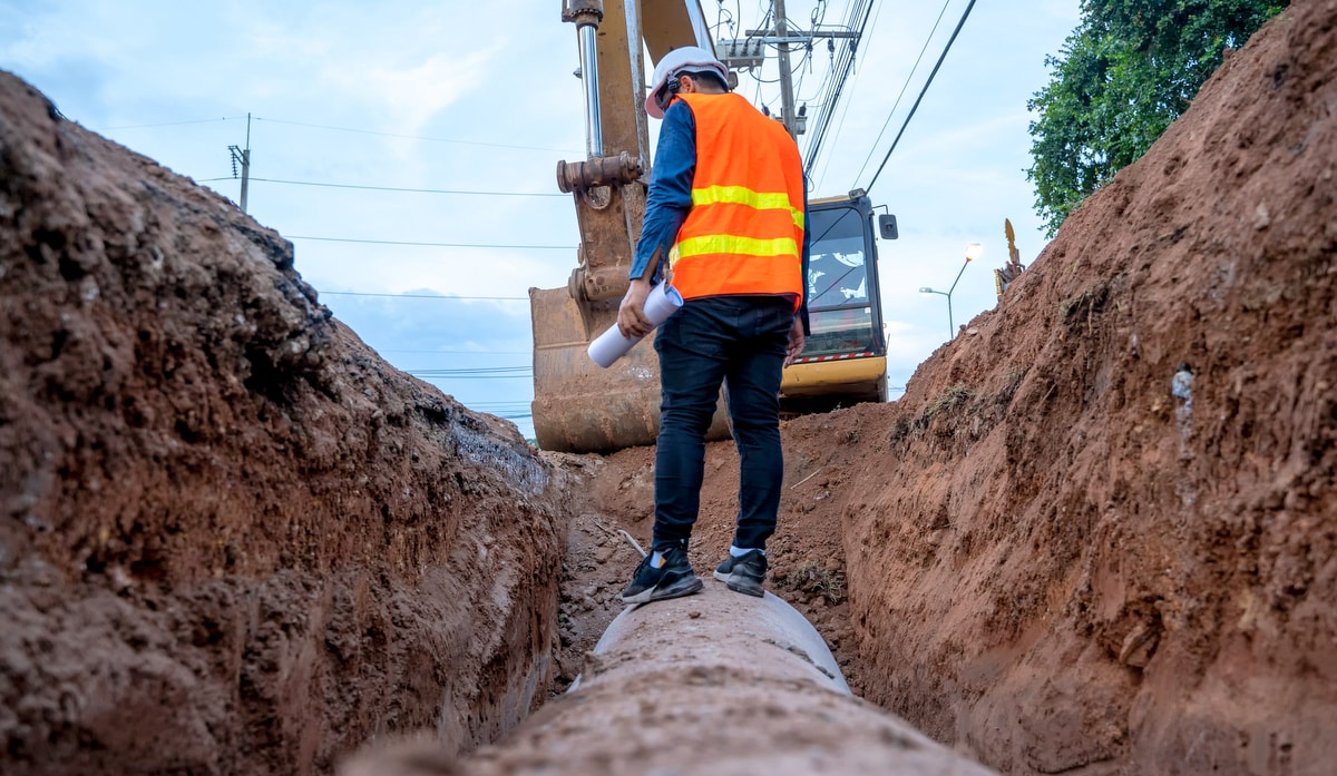 Engineer examining excavation concrete drainage pipe