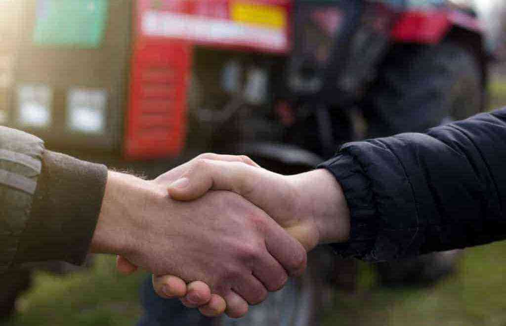 People shaking hands, signaling deal closing in agricultural machinery marketing